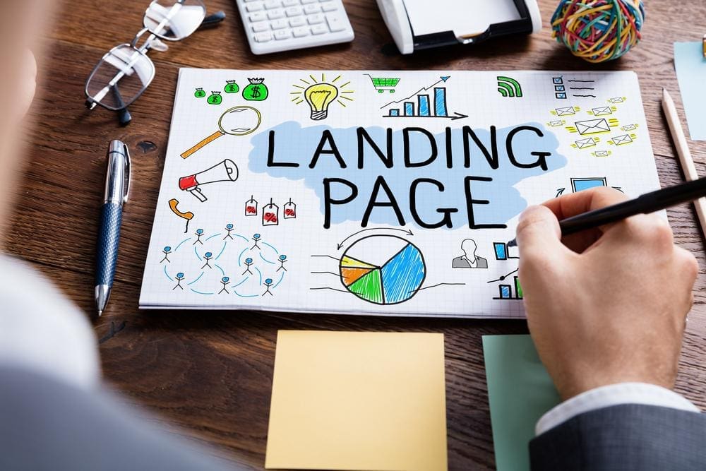 A drawing pad with sketches of graphs, charts, and SEO imagery with the words LANDING PAGE in big letters across the middle