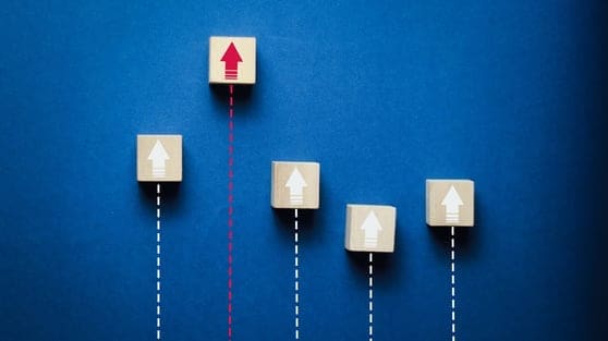 When AI Search Recommends Your Competitors: What to Track and Fix First 1 Wooden blocks with upward arrows on a blue background symbolize business growth, leadership, success, performance improvement